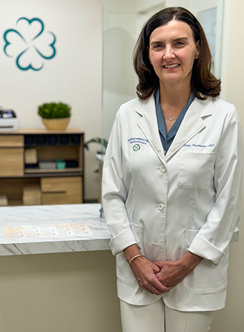 Doctor Patty Perschbacher standing with hands folded